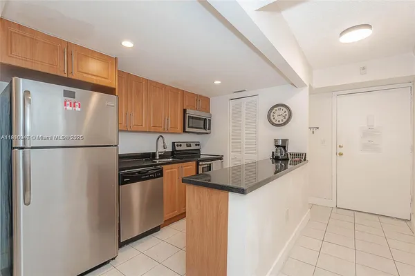 a kitchen with a refrigerator a stove top oven a sink and cabinets