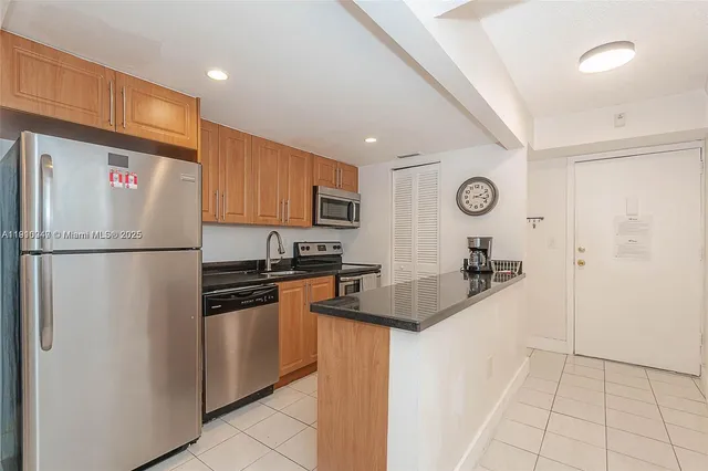 a kitchen with a refrigerator a stove top oven a sink and cabinets