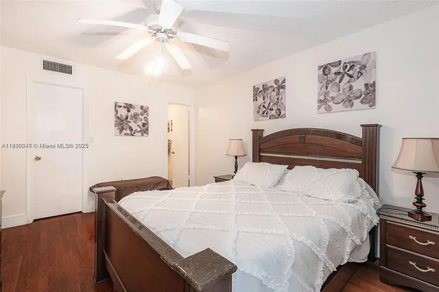 a bedroom with a bed and a lamp on dresser