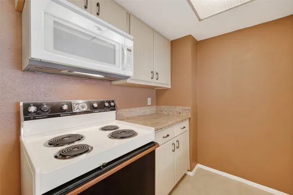 a kitchen with stainless steel appliances granite countertop a refrigerator a stove and a sink