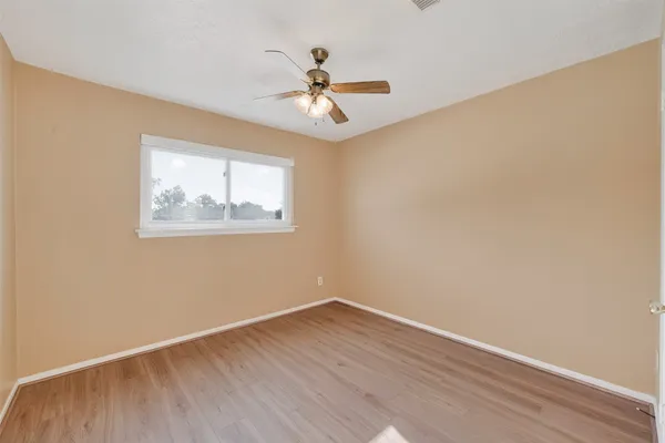 a view of a room with a ceiling fan and wooden floor