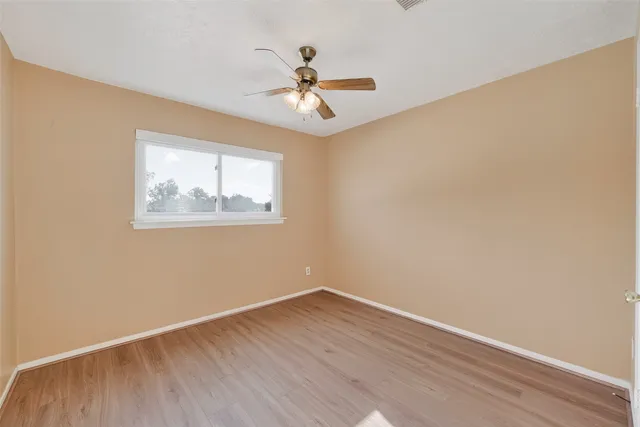a view of a room with a ceiling fan and wooden floor
