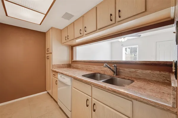 a kitchen with granite countertop white cabinets and refrigerator