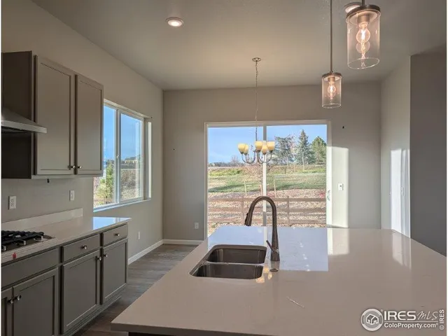 a view of a kitchen with a sink wooden cabinets and stainless steel appliances