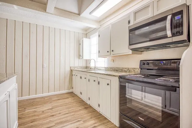 a kitchen with stainless steel appliances granite countertop a stove microwave and cabinets