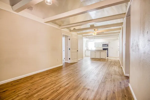 a view of empty room with wooden floor