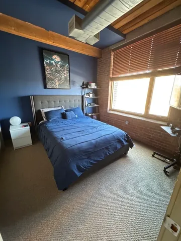 a bedroom with a bed and large windows