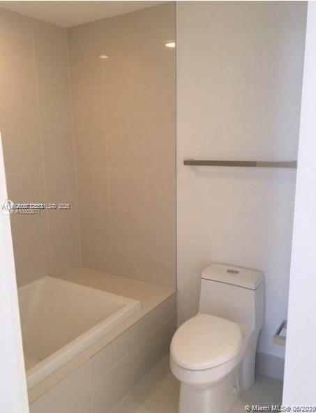 55 Southwest 9th Street, Unit 3709 Miami, FL 33130 - Photo 12 of 52 a white toilet sitting next to a bath tub