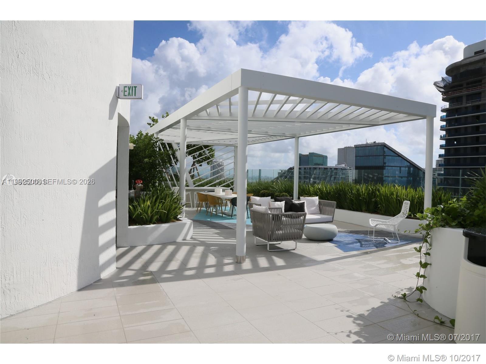 55 Southwest 9th Street, Unit 3709 Miami, FL 33130 - Photo 19 of 52 a view of a patio with a table and chairs under an umbrella
