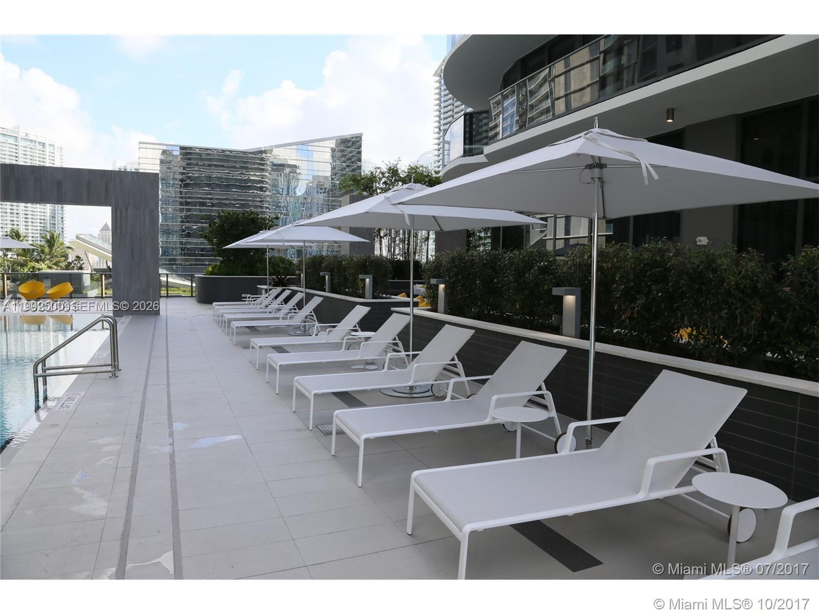 55 Southwest 9th Street, Unit 3709 Miami, FL 33130 - Photo 27 of 52 a view of a patio with table and chairs under an umbrella