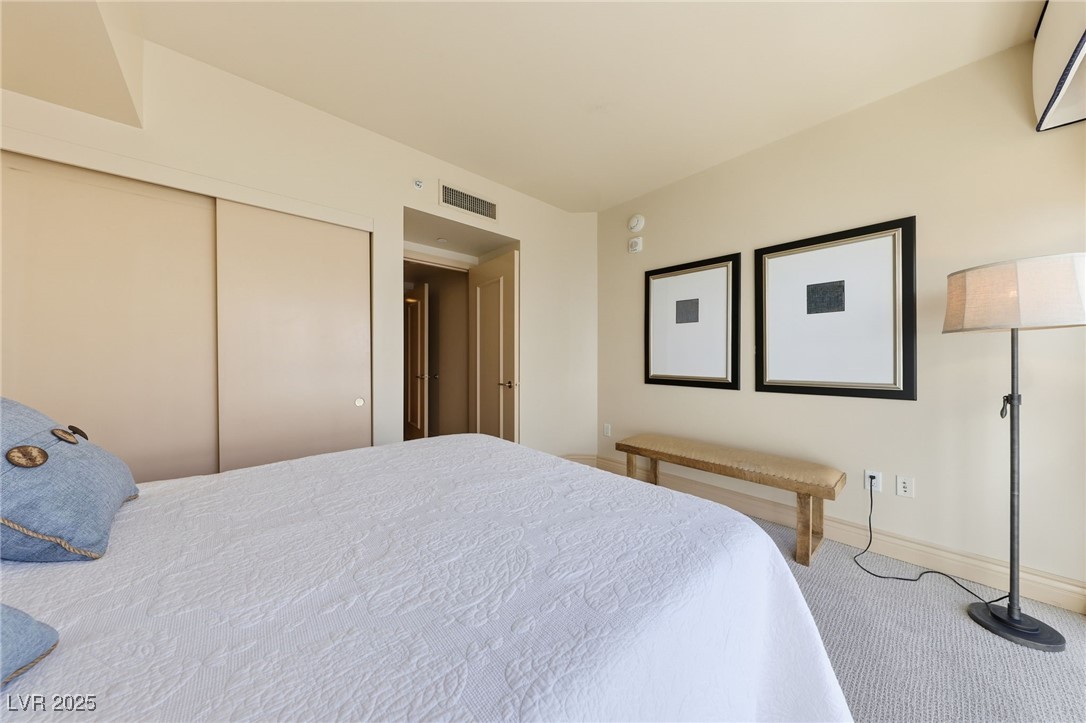 2747 Paradise Road, Unit 1205 Las Vegas, NV 89109 - Photo 4 of 32 Bedroom featuring carpet, a closet, and an AC wall unit