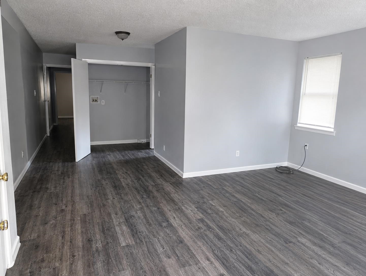 4444-4446 Sumners Wells Road Memphis, TN 38118 - Photo 2 of 8 Spacious room featuring wood-finish flooring, light gray wall paint, and white baseboards