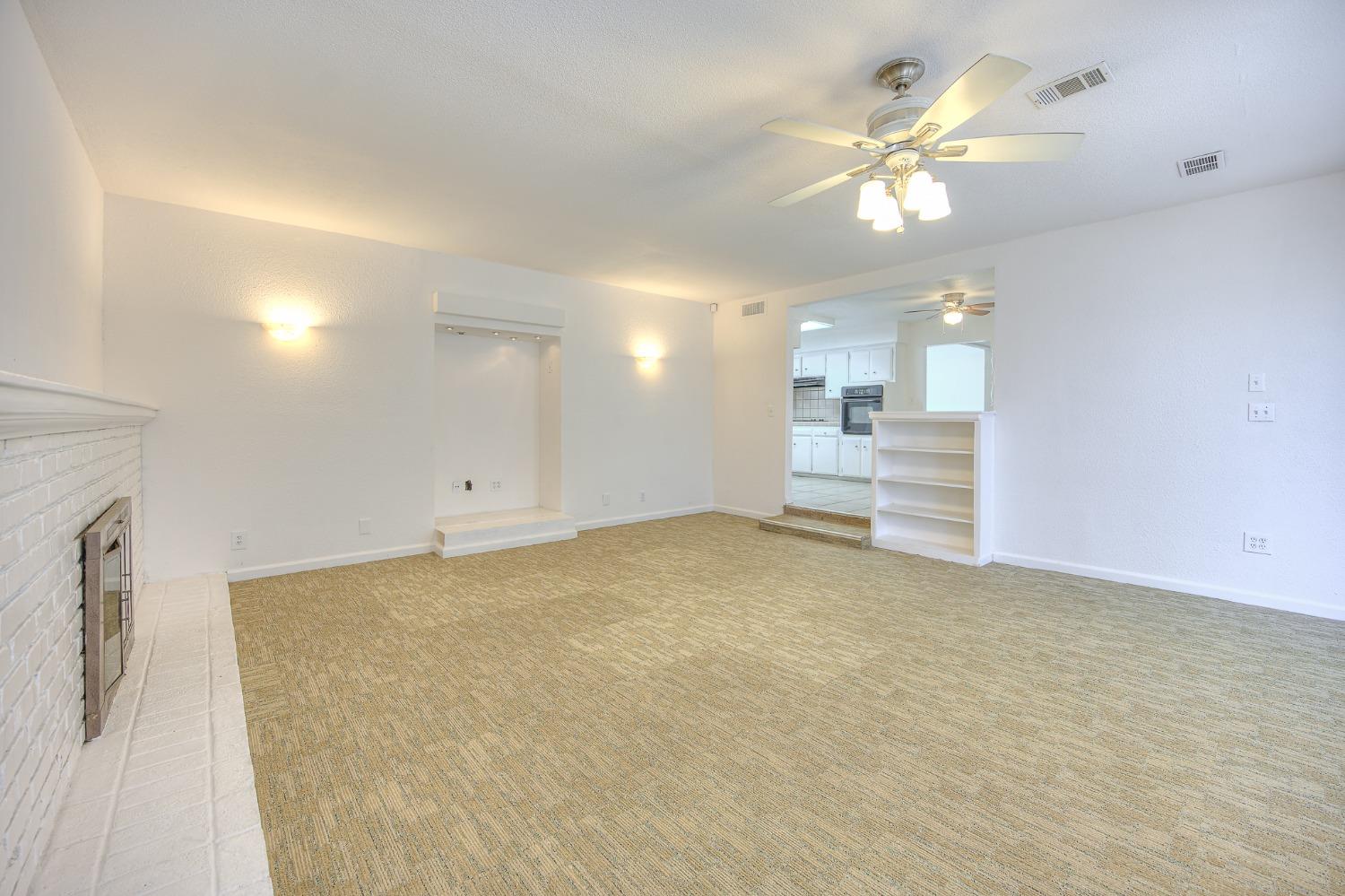 2811 North Winery Avenue Clovis, CA 93612 - Photo 14 of 25 an empty room with chandelier fan and windows