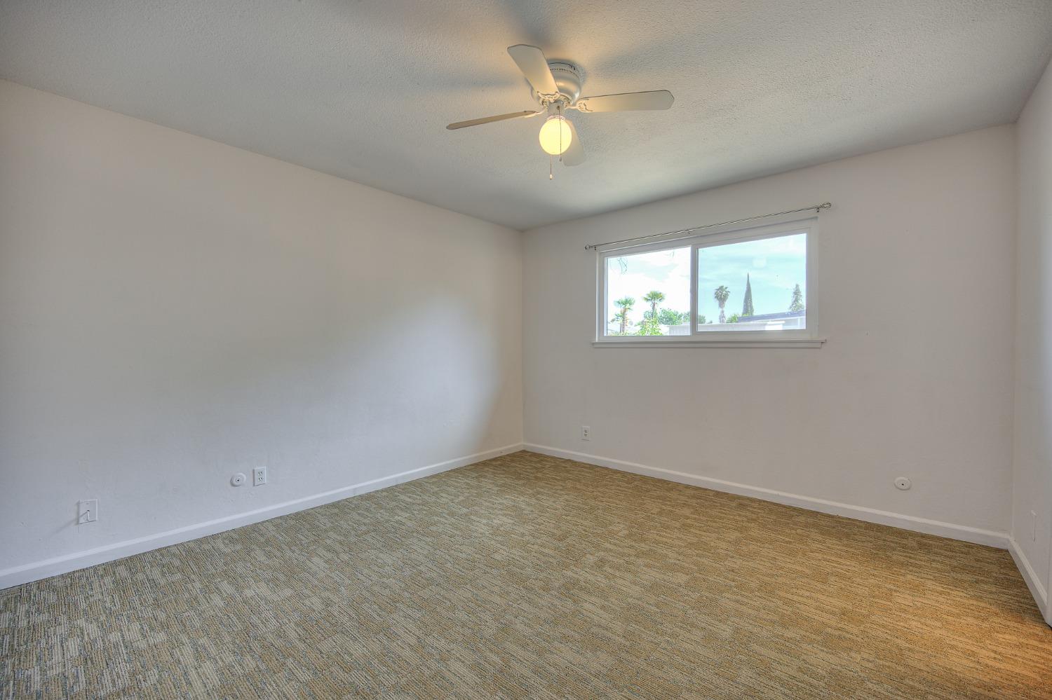 2811 North Winery Avenue Clovis, CA 93612 - Photo 18 of 25 an empty room with windows and ceiling fan view