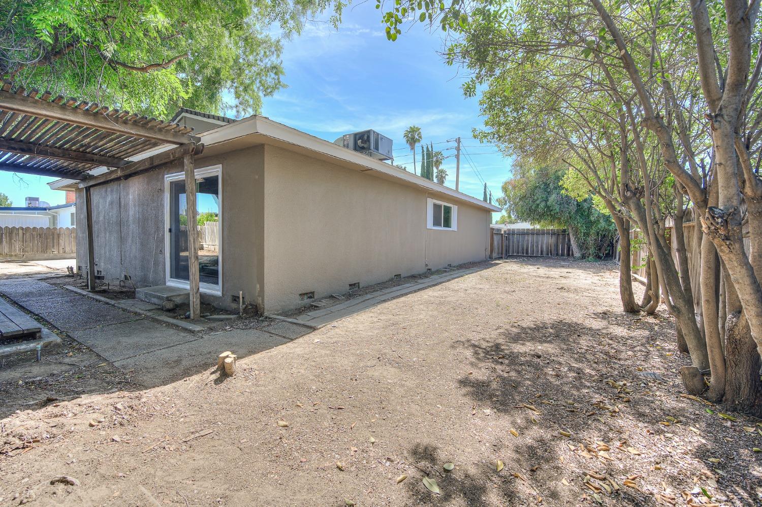 2811 North Winery Avenue Clovis, CA 93612 - Photo 23 of 25 a backyard of a house with large trees and outdoor seating