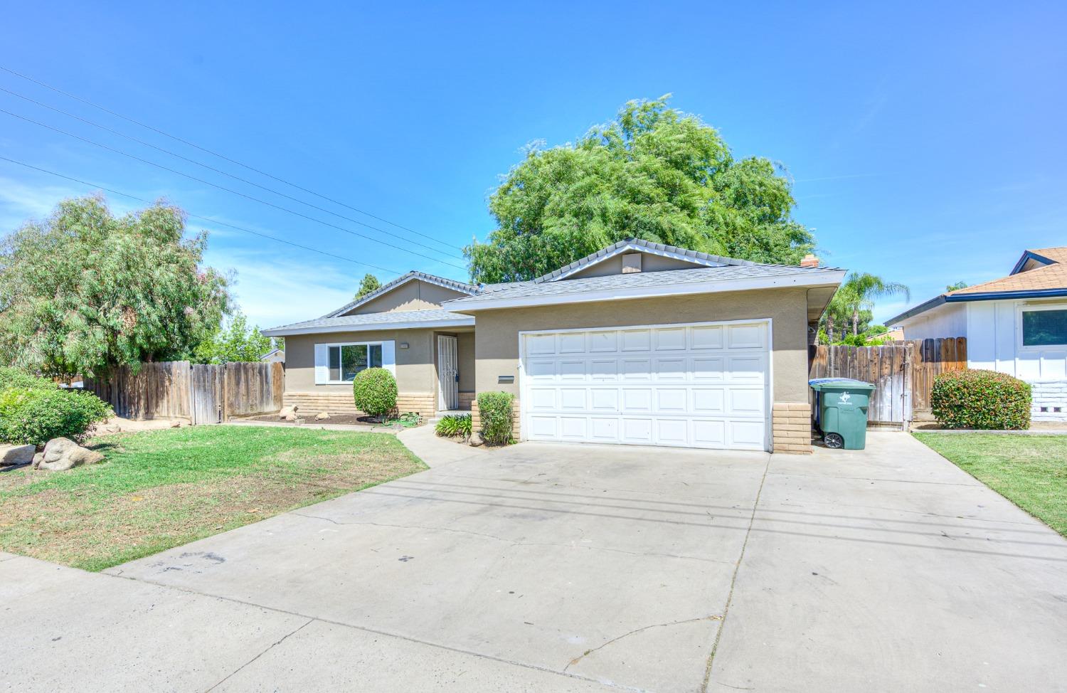 2811 North Winery Avenue Clovis, CA 93612 - Photo 3 of 25 a front view of a house with a yard and potted plants