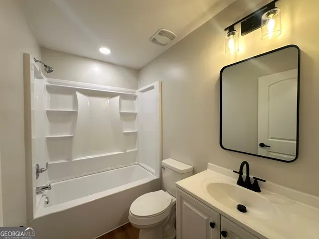 a bathroom with a toilet sink and a mirror