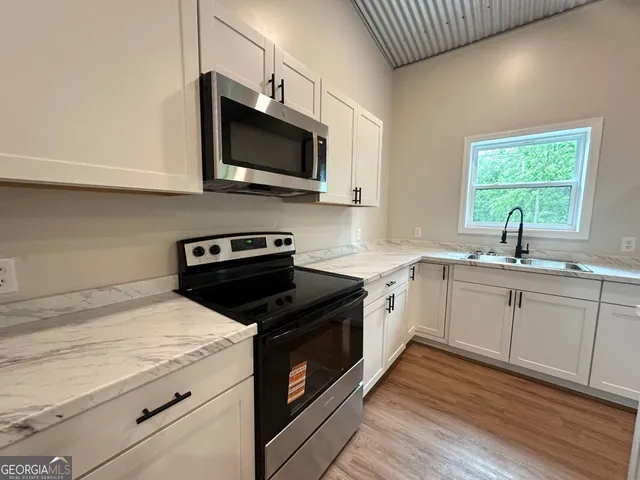 a kitchen with a sink stove and microwave