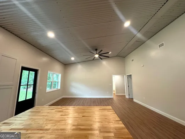 a view of empty room with wooden floor and windows