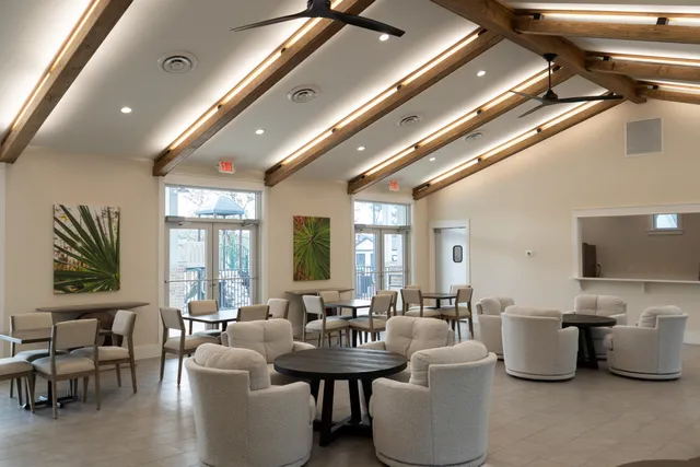 a large room with lots of white furniture and a large window