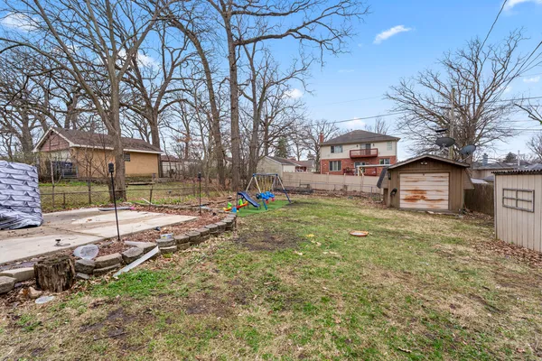 a view of a yard with a house and a large tree