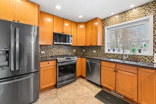 a kitchen with stainless steel appliances granite countertop a refrigerator and a sink