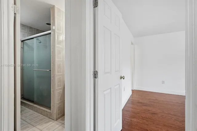 an empty room with a window and ceiling fan