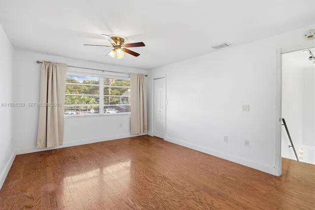 a view of a room with a window and wooden floor