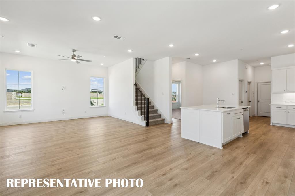 1034 Splitrock Drive Allen, TX 75013 - Photo 18 of 18 a view of an empty room with wooden floor and a kitchen