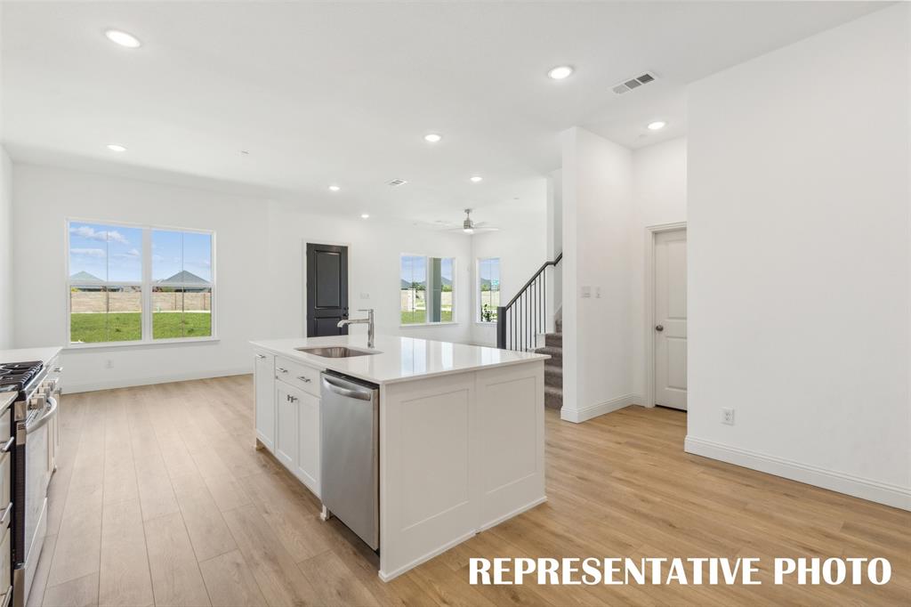1034 Splitrock Drive Allen, TX 75013 - Photo 6 of 18 a kitchen with stainless steel appliances granite countertop a sink stove and wooden floor