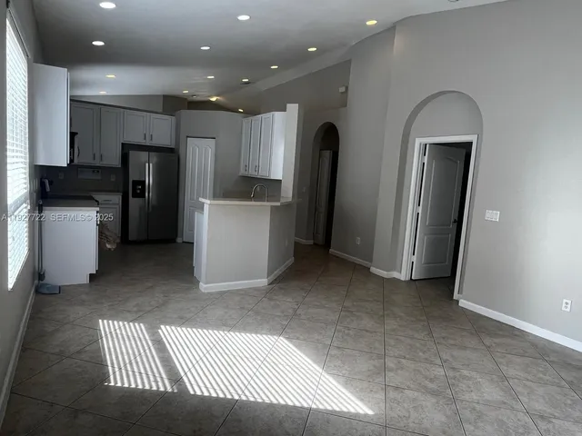 a kitchen with refrigerator and cabinets