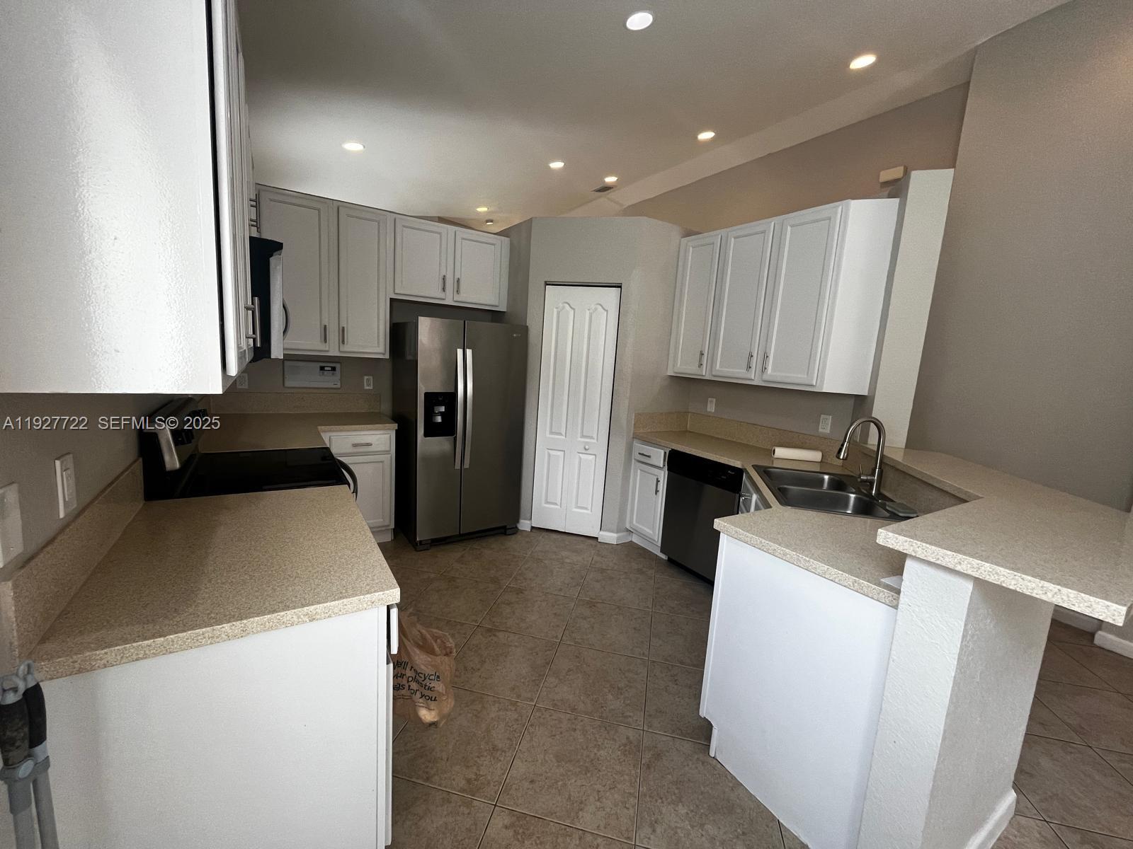2219 Portofino Avenue Homestead, FL 33033 - Photo 6 of 9 a view of a kitchen with a sink dishwasher and a refrigerator
