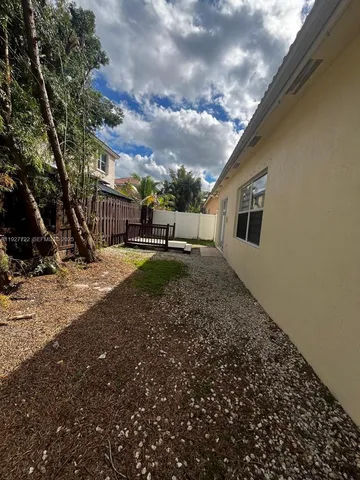 a backyard of a house with barbeque oven table and chairs