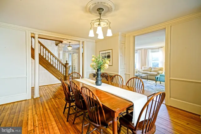a view of a a dining room with furniture window and wooden floor