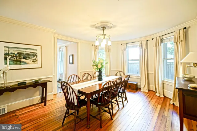 a view of a a dining room with furniture window and wooden floor
