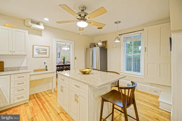 a kitchen with granite countertop a sink stainless steel appliances white cabinets and a window