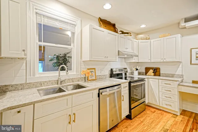 a kitchen with granite countertop white cabinets and white appliances