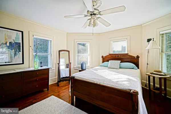 a bedroom with a large bed and ceiling fan