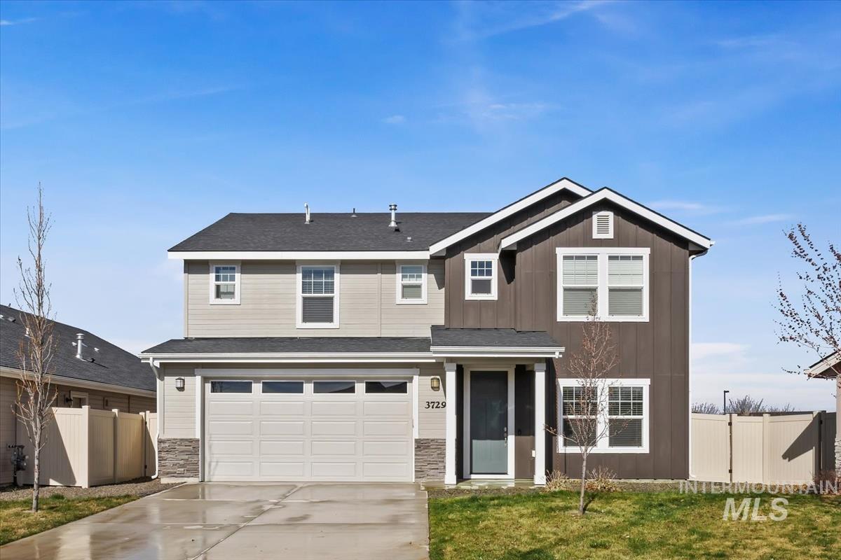 View of front of home featuring concrete driveway, a garage, stone siding, and board and batten siding