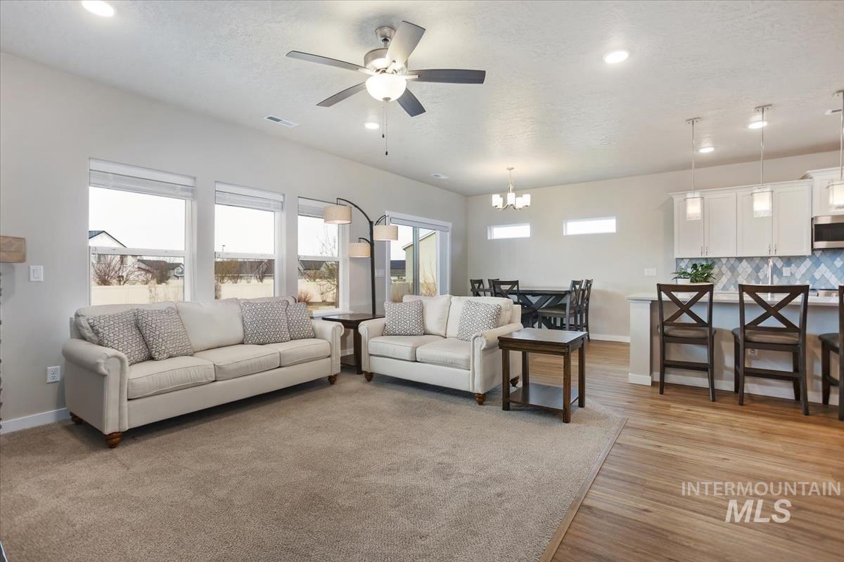 3729 South Maple Ridge Avenue Nampa, ID 83686 - Photo 10 of 46 Living room featuring ceiling fan, light wood-type flooring, and a chandelier
