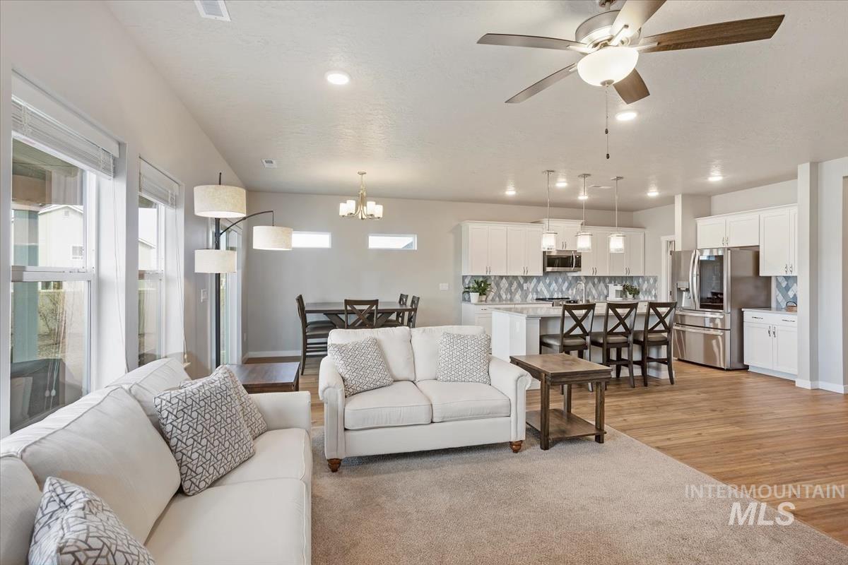 3729 South Maple Ridge Avenue Nampa, ID 83686 - Photo 11 of 46 Living room featuring light wood-style floors, ceiling fan, and suspended lighting