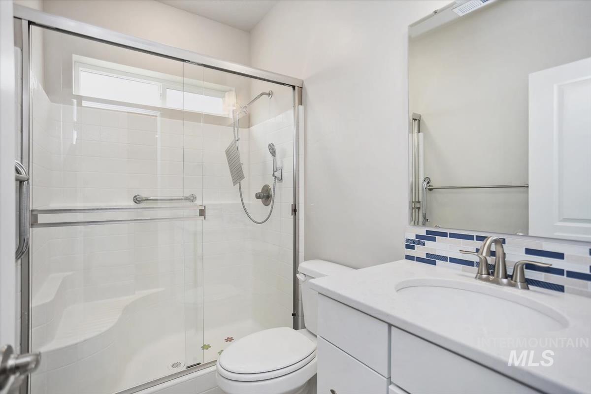 3729 South Maple Ridge Avenue Nampa, ID 83686 - Photo 18 of 46 Bathroom with vanity, a shower stall, and decorative backsplash