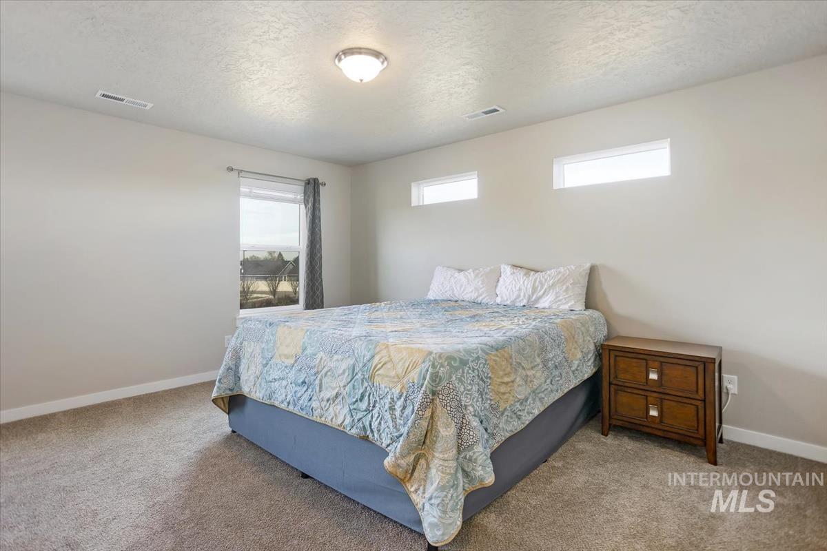3729 South Maple Ridge Avenue Nampa, ID 83686 - Photo 21 of 46 Bedroom featuring a textured ceiling and light carpet