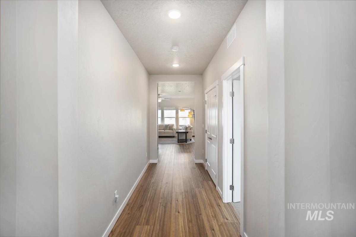 3729 South Maple Ridge Avenue Nampa, ID 83686 - Photo 3 of 46 Hall with dark wood-style floors and a textured ceiling