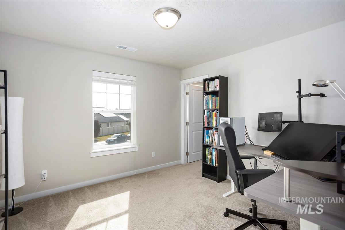 3729 South Maple Ridge Avenue Nampa, ID 83686 - Photo 32 of 46 Home office with light carpet and baseboards