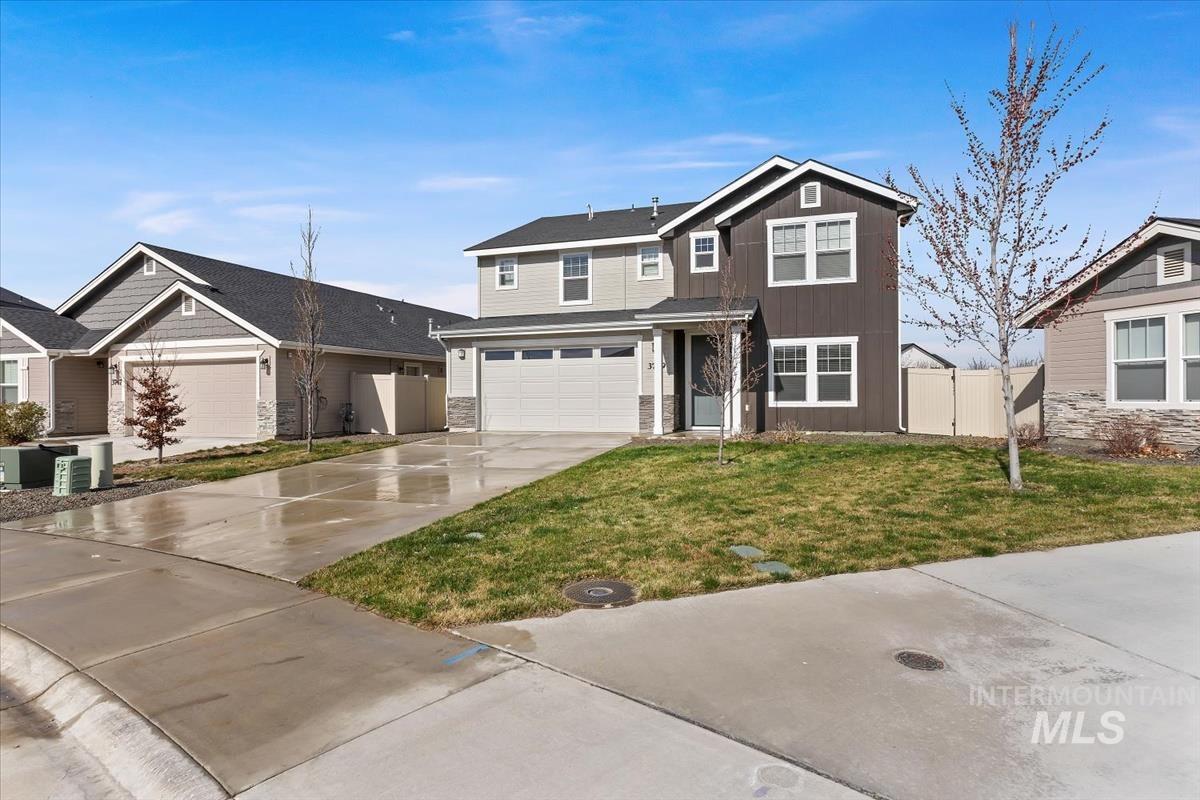 3729 South Maple Ridge Avenue Nampa, ID 83686 - Photo 43 of 46 View of front of home featuring a gate, concrete driveway, an attached garage, and stone siding