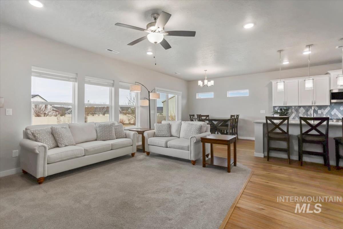 3729 South Maple Ridge Avenue Nampa, ID 83686 - Photo 5 of 46 Living area featuring ceiling fan, healthy amount of natural light, light wood-type flooring, and suspended lighting