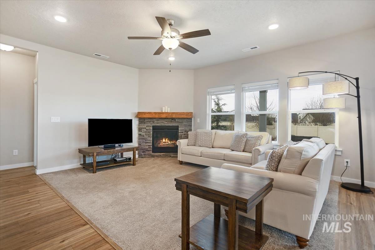 3729 South Maple Ridge Avenue Nampa, ID 83686 - Photo 9 of 46 Living room with ceiling fan, a stone fireplace, light wood-style flooring, and recessed lighting