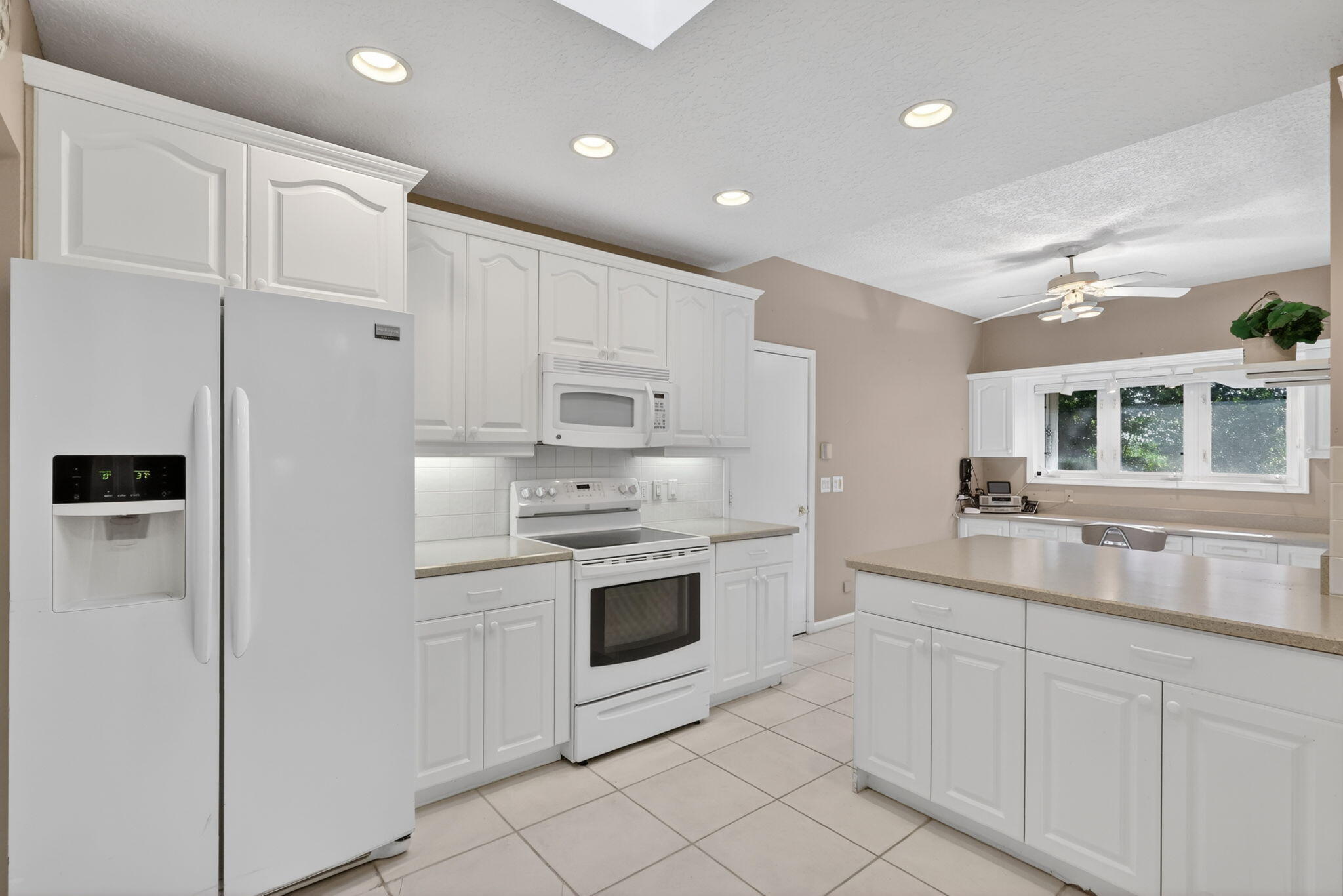 5422 Southeast Meredith Terrace Stuart, FL 34997 - Photo 16 of 56 a kitchen with white cabinets and white appliances