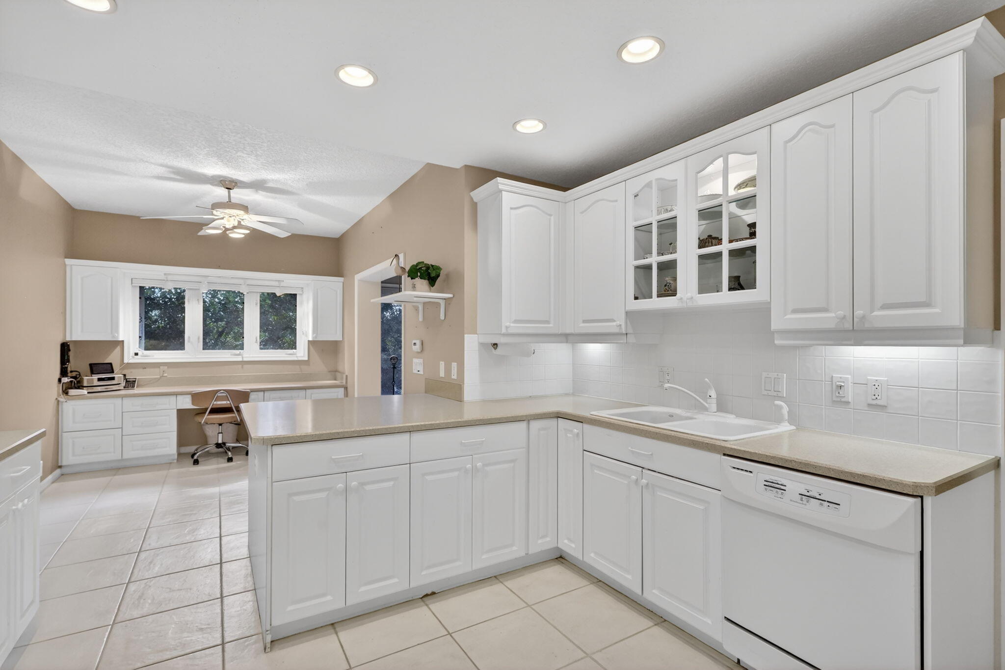 5422 Southeast Meredith Terrace Stuart, FL 34997 - Photo 17 of 56 a kitchen with a sink dishwasher and white cabinets with wooden floor